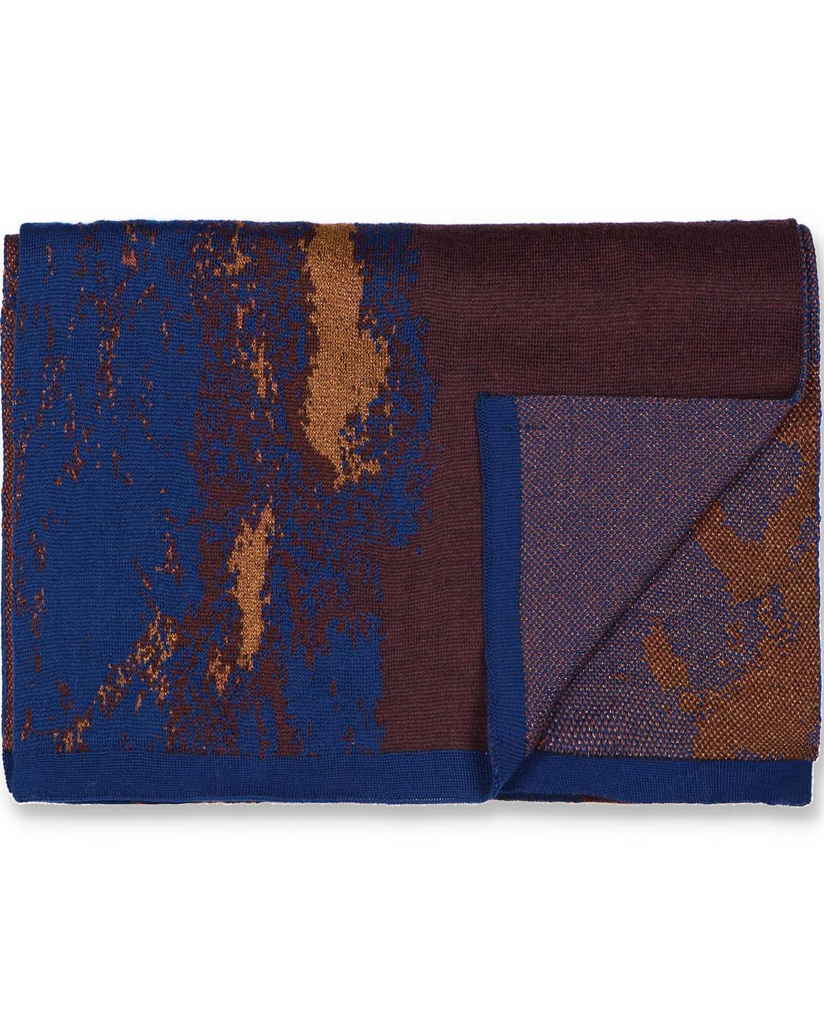 Flatlay of a knit scarf in blue and brown with gold and copper details. The background is white.