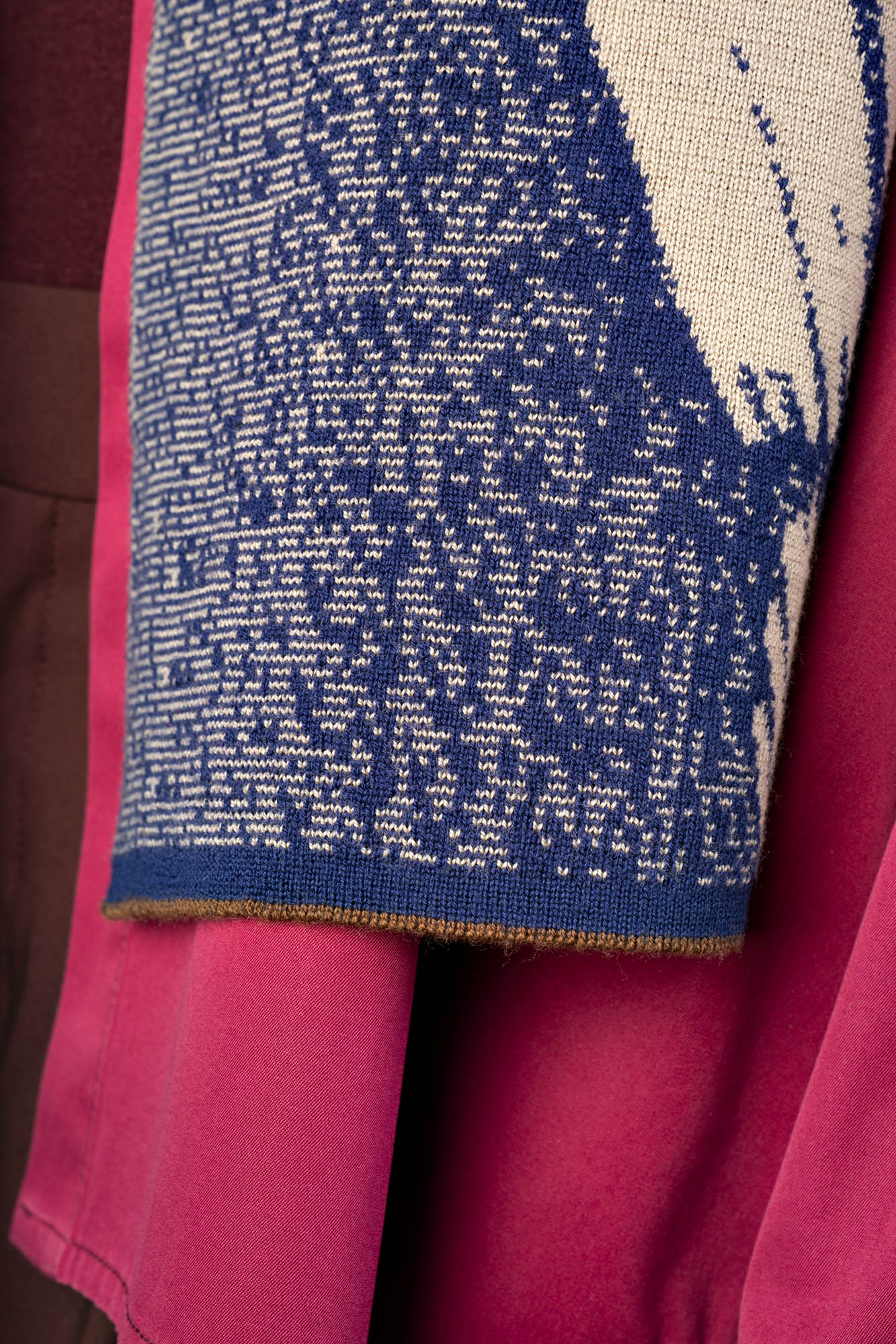 Close-up of a dark blue and beige scarf with cacao brown detail at the end.